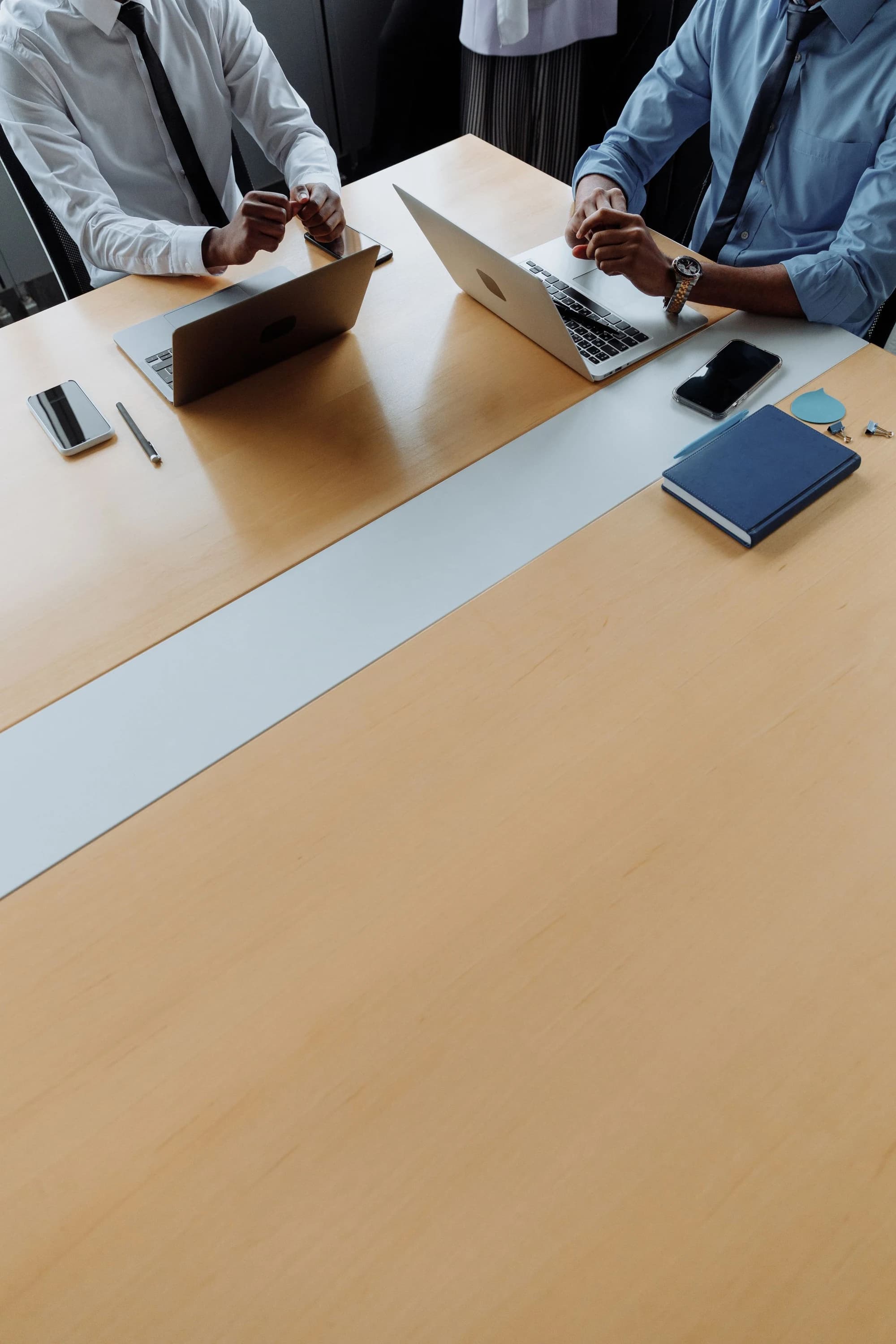 An organized desk with a notebook, phone and working materials