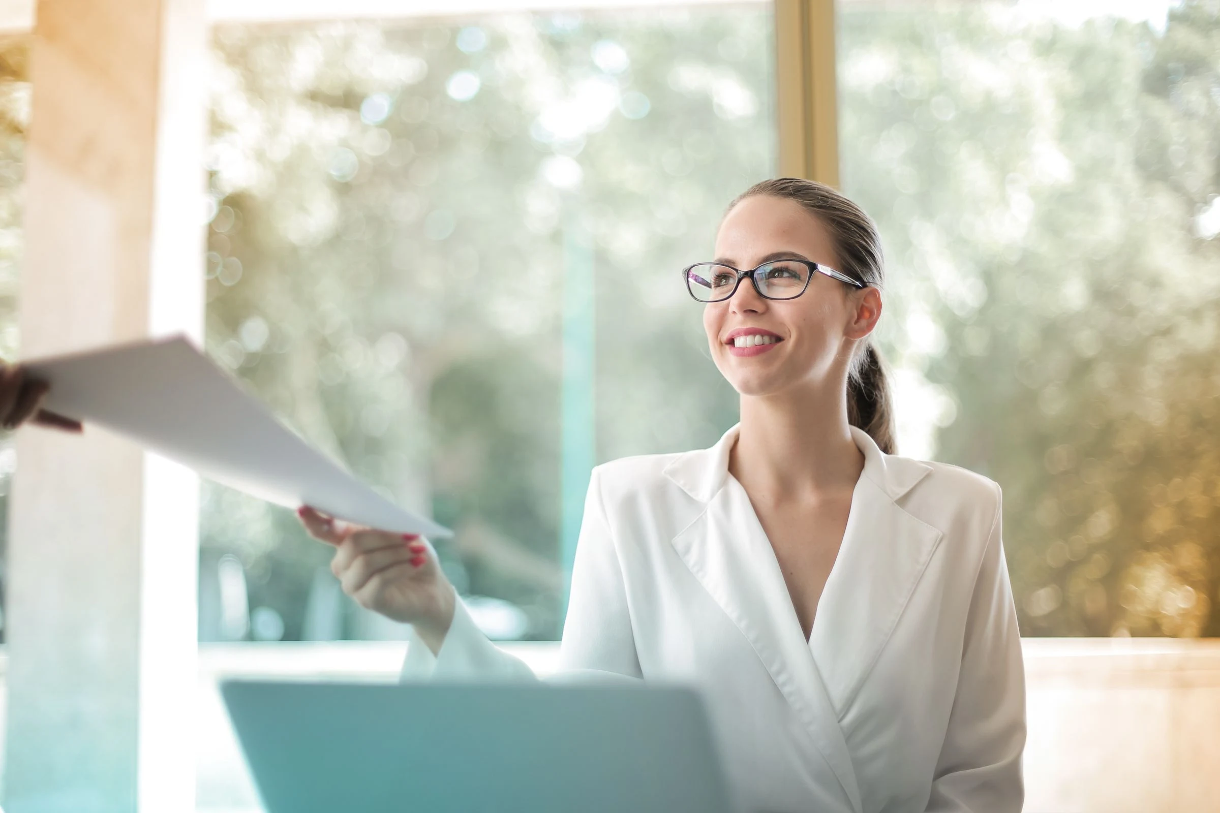 A professional reviewing documents at her desk